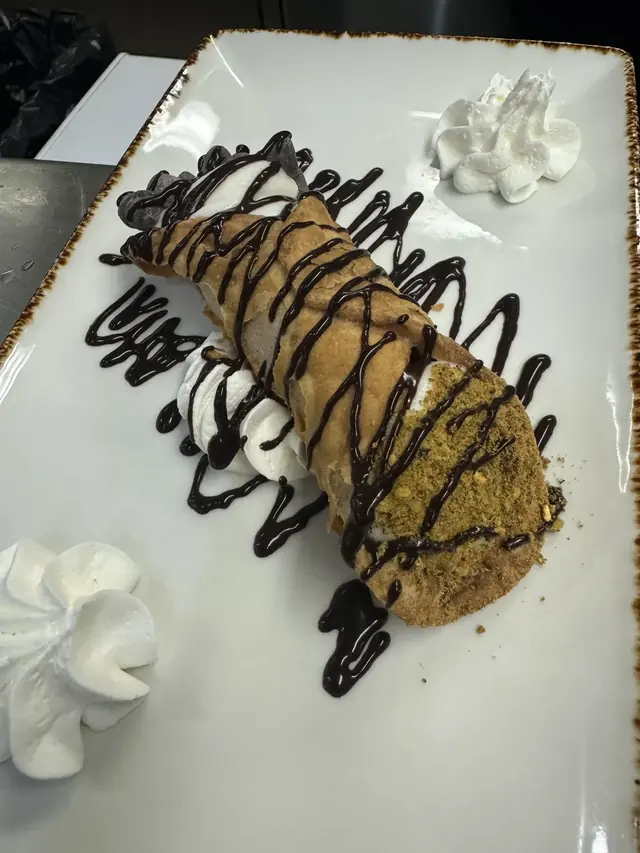 Dessert plated with chocolate drizzle and whipped cream